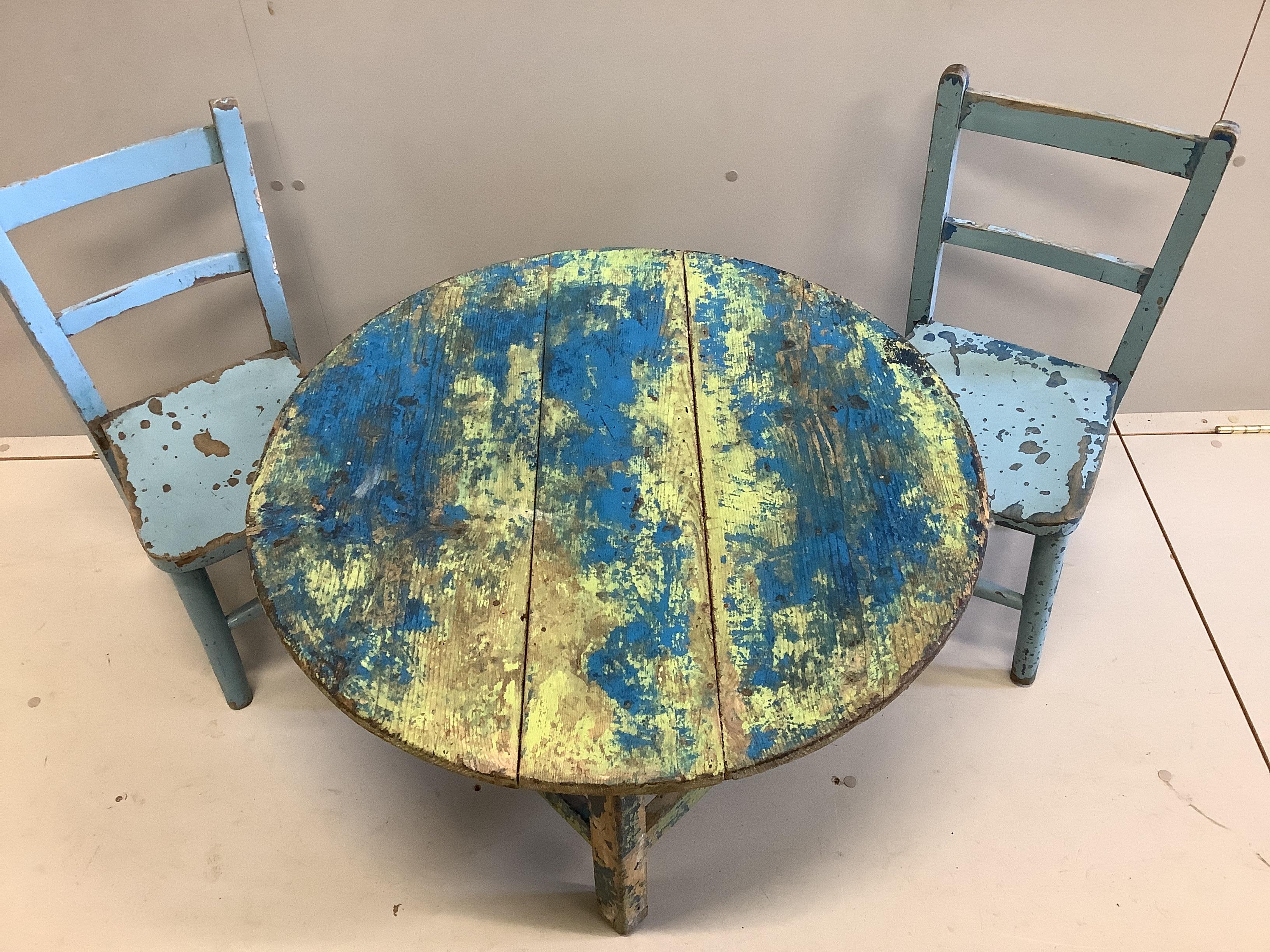 A circular painted pine low table, diameter 75cm together with two painted child's chairs